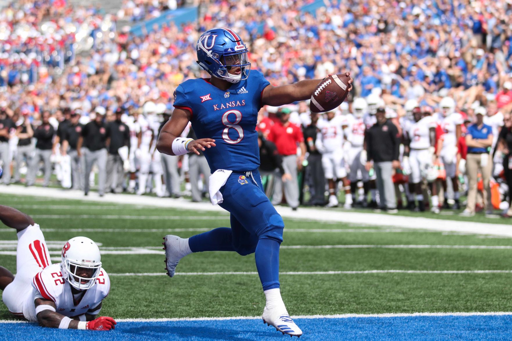Miles Kendrick runs into the endzone with his left arm extended holding the football